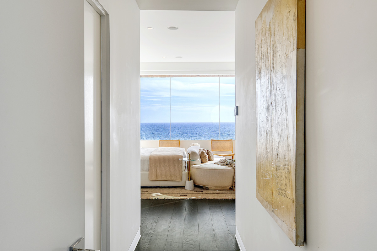 entryway to master bedroom with a bed and large window showing ocean views