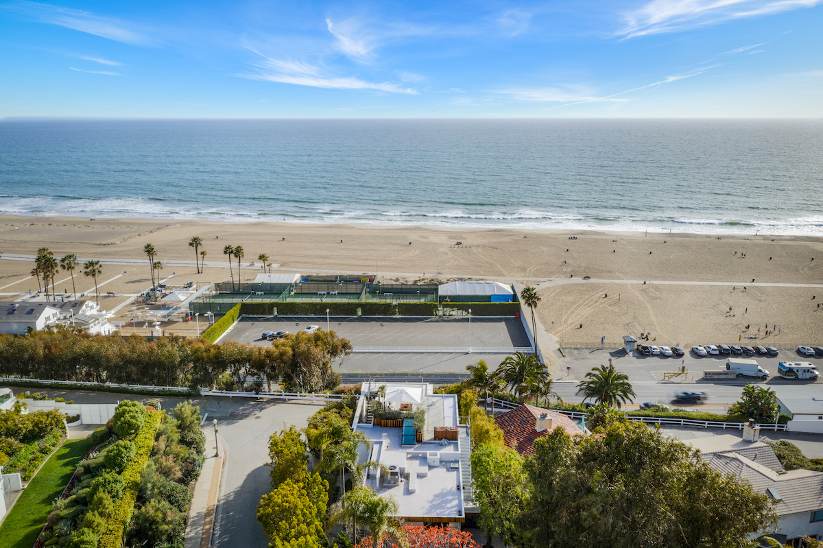 aerial view of a beachfront home on the sand