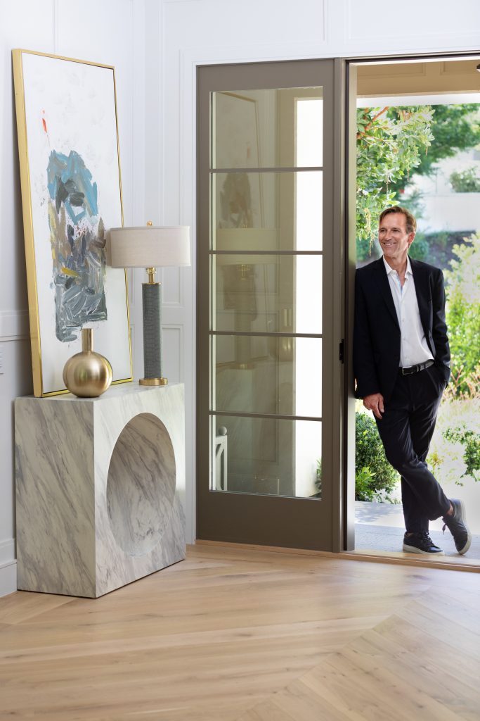 Realtor standing in the open doorway of a beautiful Pacific Palisade home